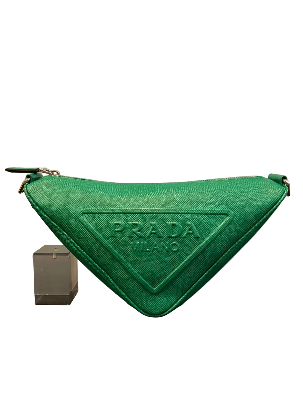 Green Prada pouch on a reflective surface with a neutral background