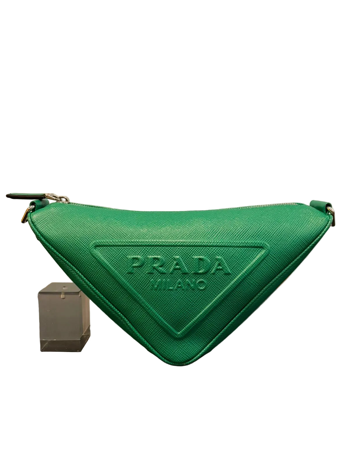 Green Prada pouch on a reflective surface with a neutral background