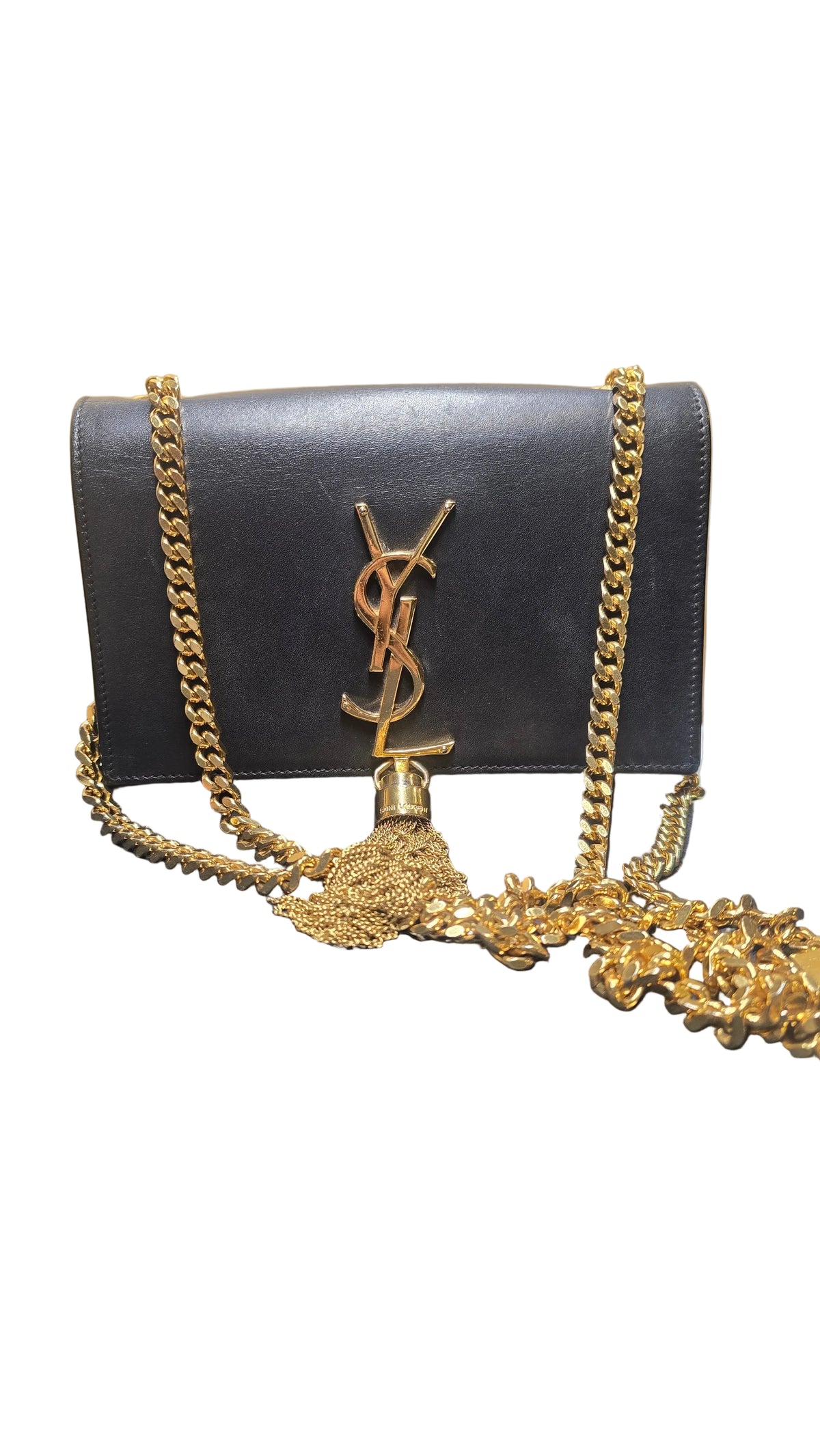 Black  YSL clutch bag with gold chain and Yves Saint Laurent logo on a wooden surface.